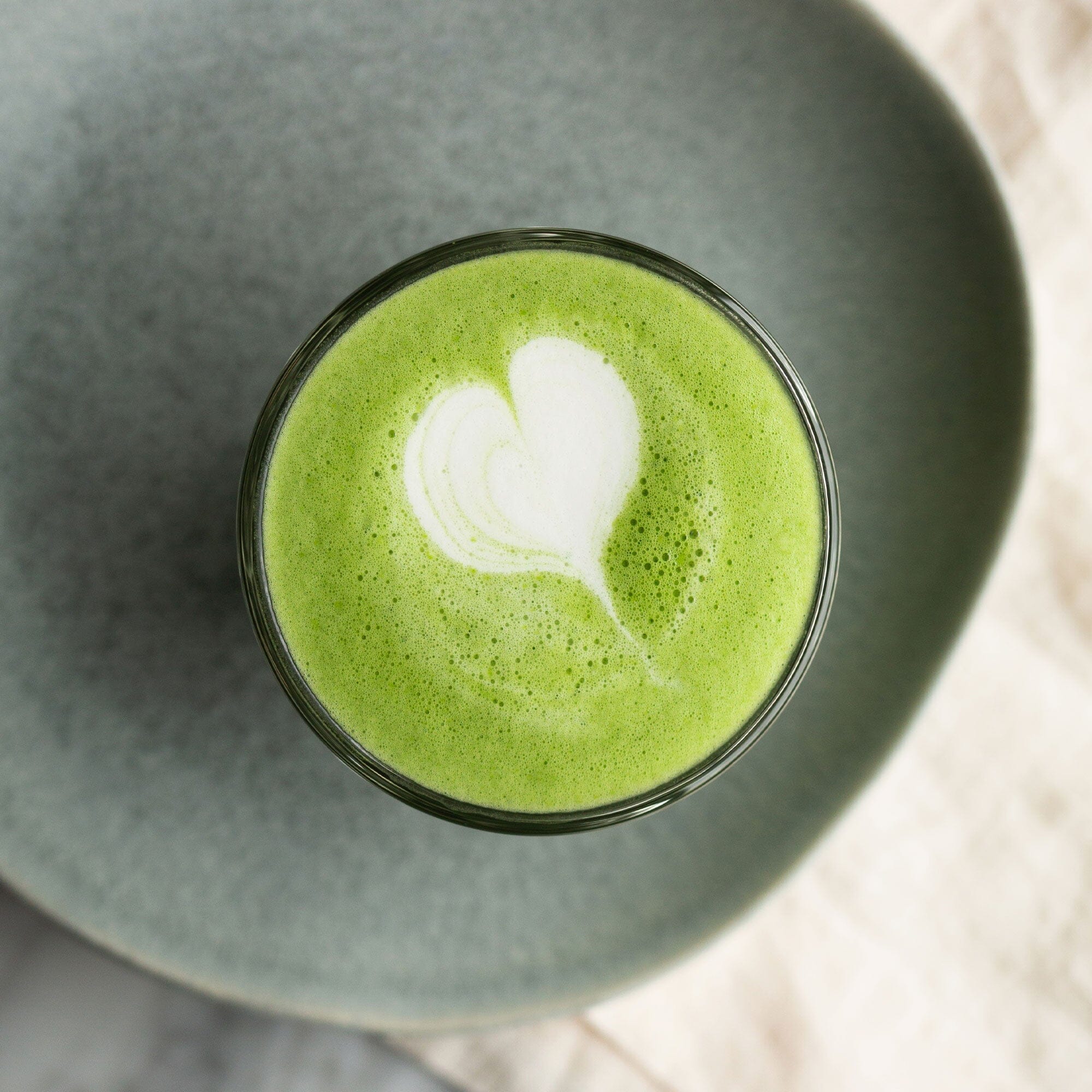 A cup of Everyday Matcha green tea with a heart on top from Rishi Tea & Botanicals.