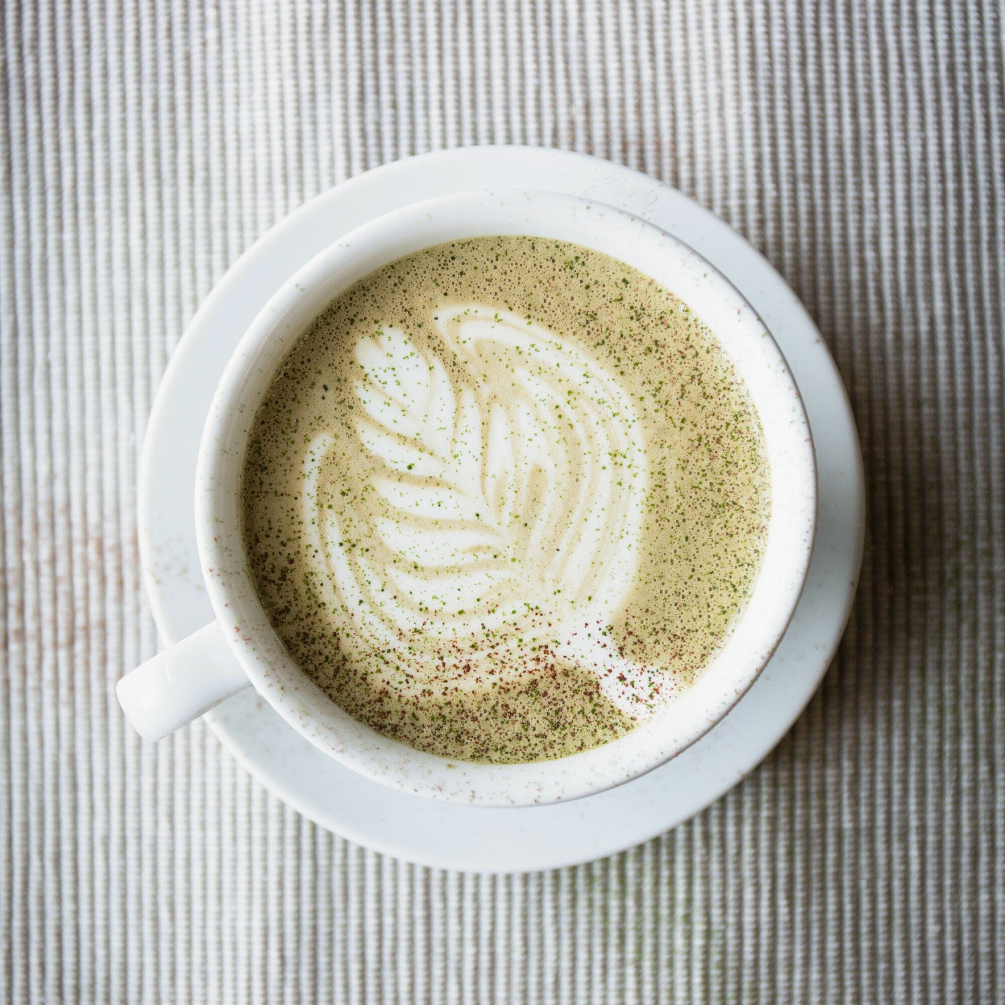 A cup of Rishi Tea & Botanicals Sweet Houjicha Cocoa with latte art on top, viewed from above.