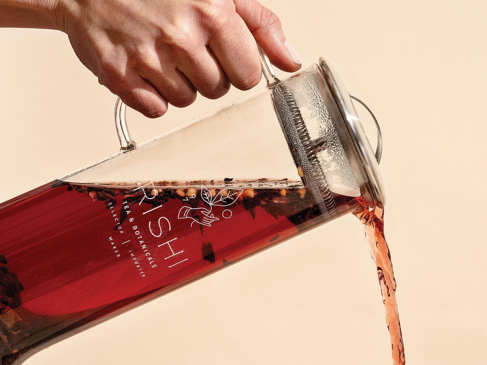 A person pouring tea into a Simple Brew Loose Leaf Teapot pitcher made by Eilong Enterprise Co., Ltd.