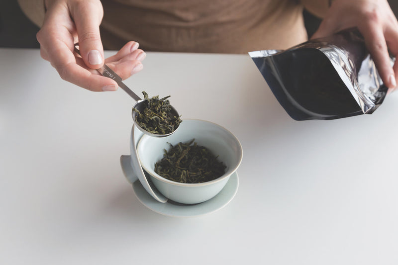 Close-up of gentle spoons of Rishi loose leaf tea into the gaiwan