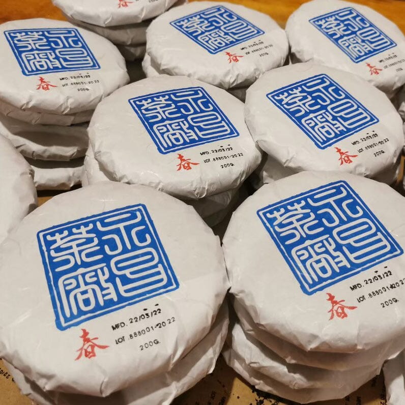 A stack of Rishi Tea & Botanicals Doi Wawee Sheng Pu'er Vintage Spring 2022 on a table.