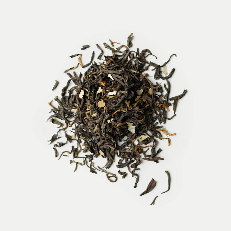 A pile of loose-leaf black tea blended with Mediterranean botanicals and small bits of dried herbal ingredients.