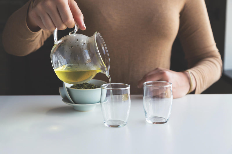 After demonstrating how to use a Gaiwan, the individual pours the tea into clear teacups