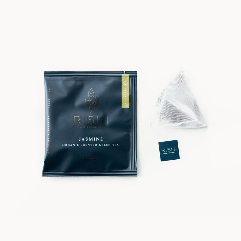 A Jasmine tea bag with a Rishi Tea & Botanicals tea bag next to it.