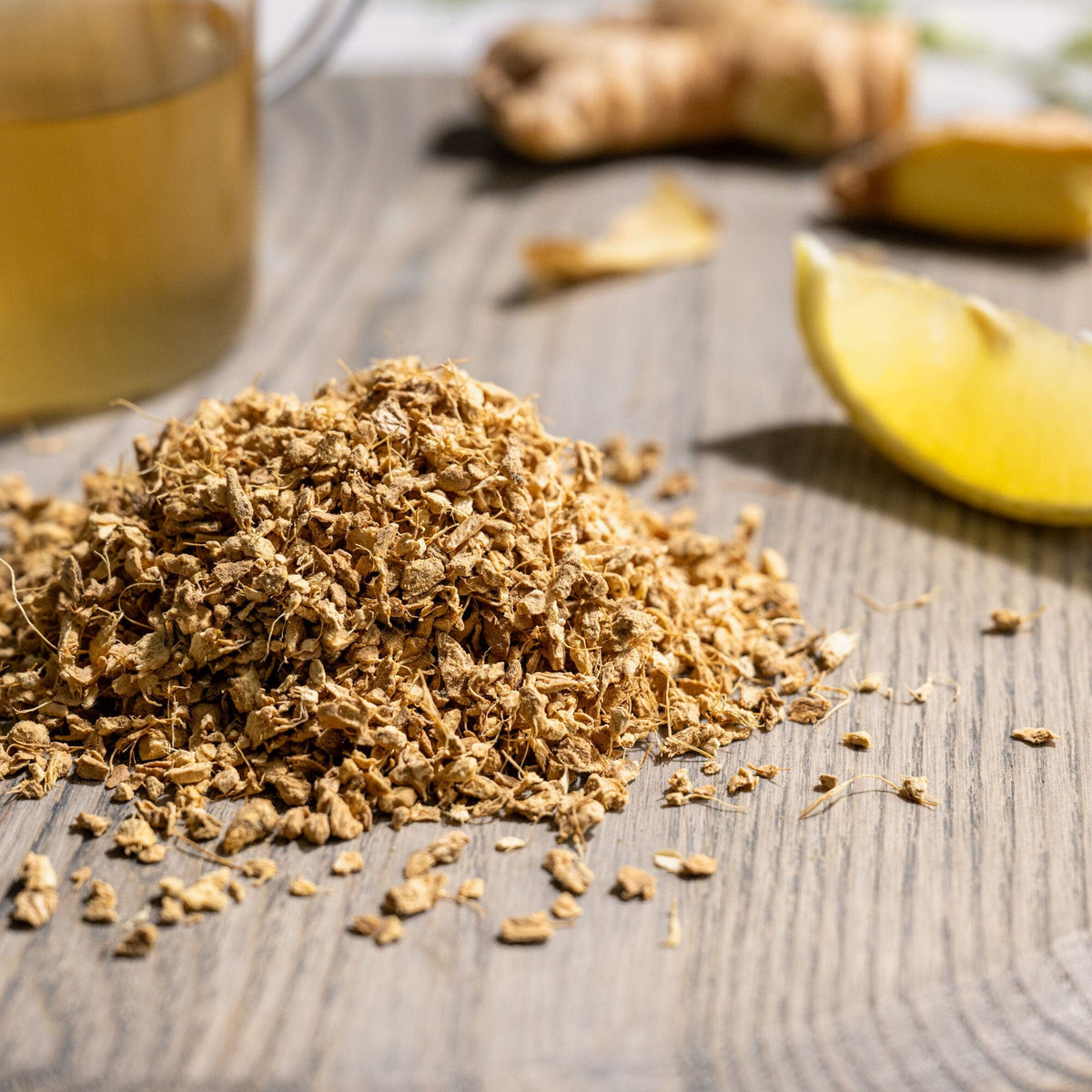 A bowl of Rishi Tea & Botanicals granulated ginger and lemon on a wooden table.