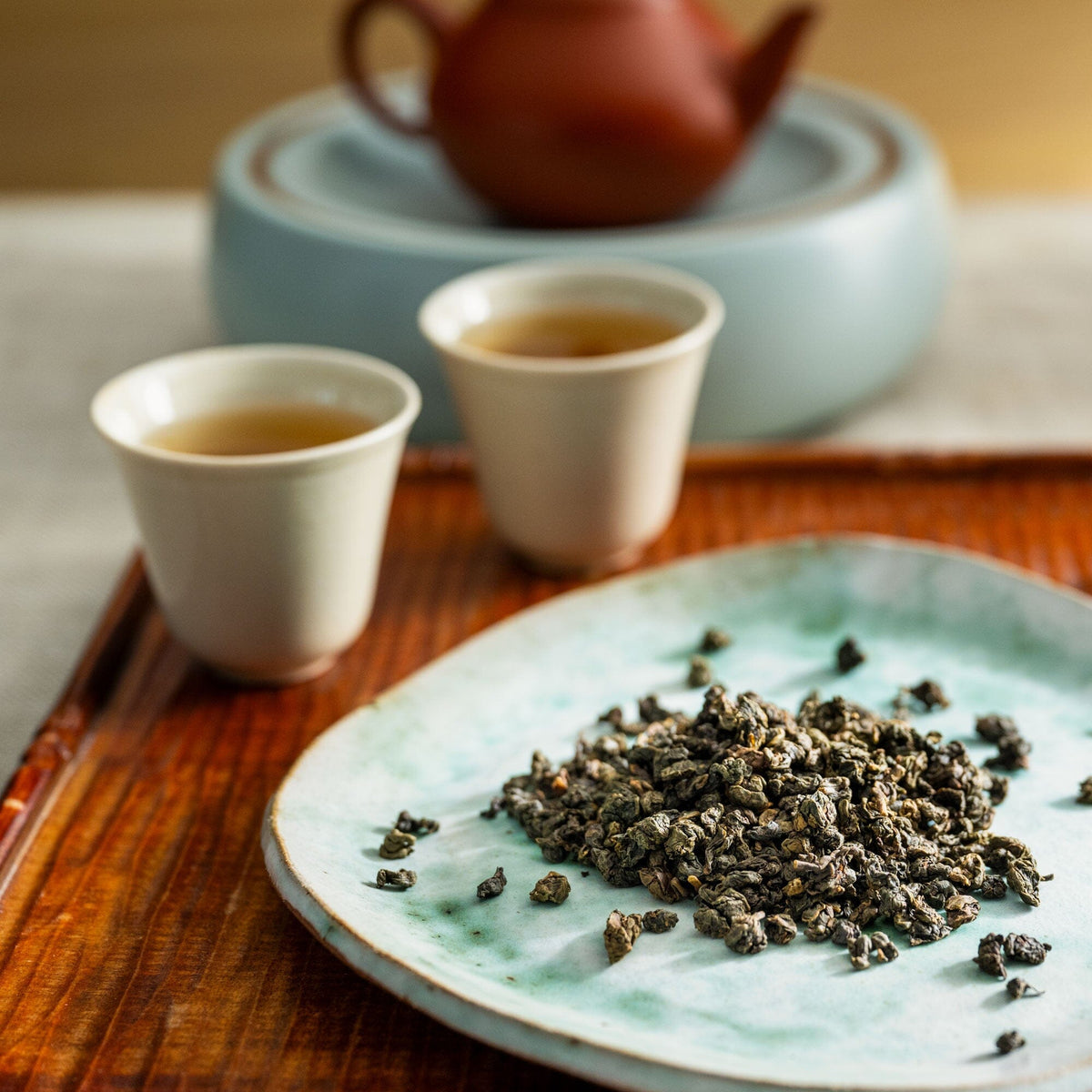 A plate with a cup of Iron Goddess of Mercy tea and a bowl of goji berries from Rishi Tea & Botanicals.