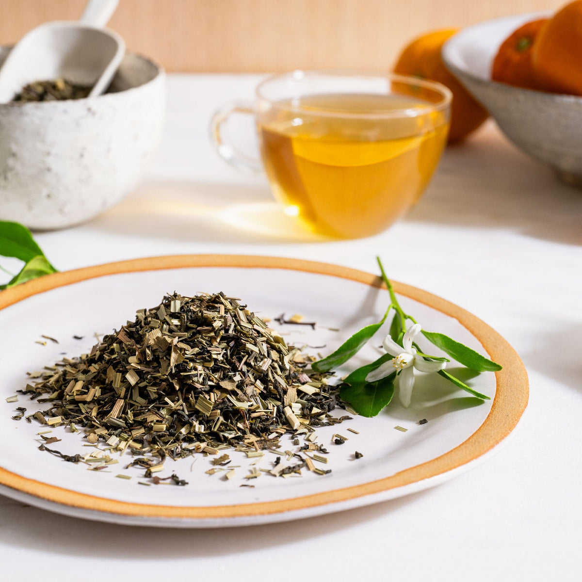 A plate with Orange Blossom tea leaves and oranges on it, from Rishi Tea & Botanicals.