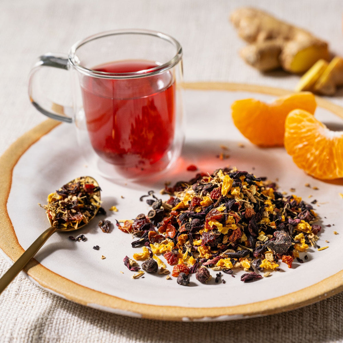 A plate with a cup of Tangerine Ginger tea and oranges on it from Rishi Tea & Botanicals.