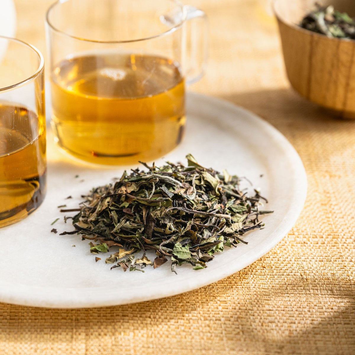 A White Peony-Organic Plate with two Rishi Tea & Botanicals cups of tea on it.