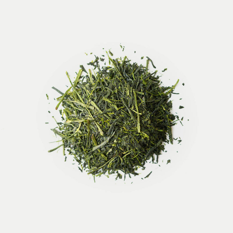 A pile of Rishi Tea & Botanicals Yutaka Midori loose-leaf green tea, prized for its rich umami notes, displayed on a white background.