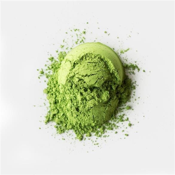 A pile of bright green Rishi Tea & Botanicals Samidori matcha powder, made from prized first-flush leaves, is spread on a white surface.