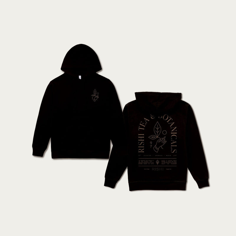 Two Rishi Everyday Hoodies - Black are displayed, one showing the front and the other the back. Both feature Rishi Tea & Botanicals branding with a botanical design. Crafted from organic cotton fleece, these unisex fit hoodies are perfect for everyday wear.