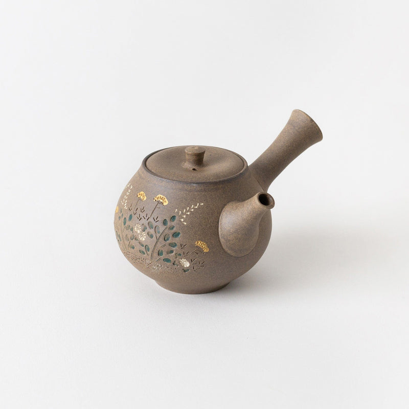 A round yakishime kyusu teapot by Chato Co., Ltd., crafted from brown shudei clay with a side handle and spout, features a green, yellow, and white floral design.