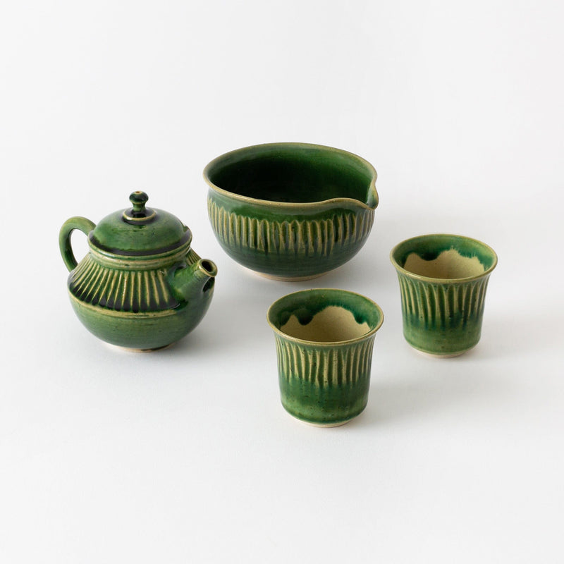 A green Rishi Tea & Botanicals Oribe Tokoname teaware set with vertical yellowish accents, including a kyusu teapot, spouted bowl, and two cups, displayed on a plain white background.