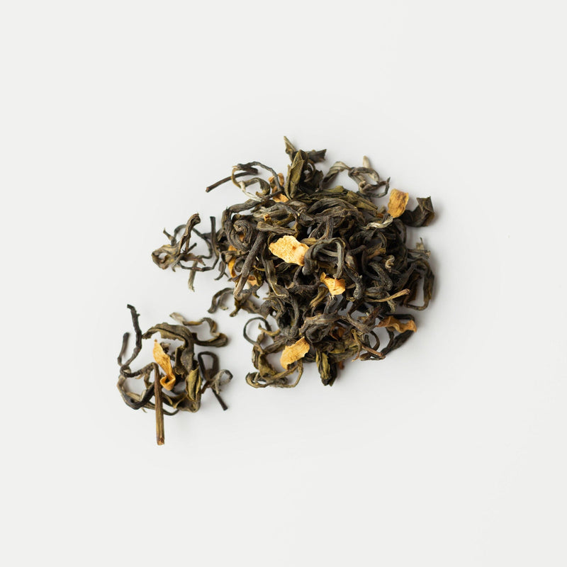 Rishi Tea & Botanicals Snow Shan loose leaf green tea features visible dried fruit and flower pieces, ideal for fans of delicate Vietnamese floral aromas, shown on a white background.