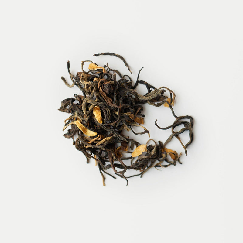 A small pile of loose leaf Snow Shan red tea with visible golden tips from Rishi Tea & Botanicals, displayed on a plain white background.